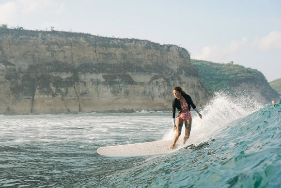 Kassia Meador surfing at sunset